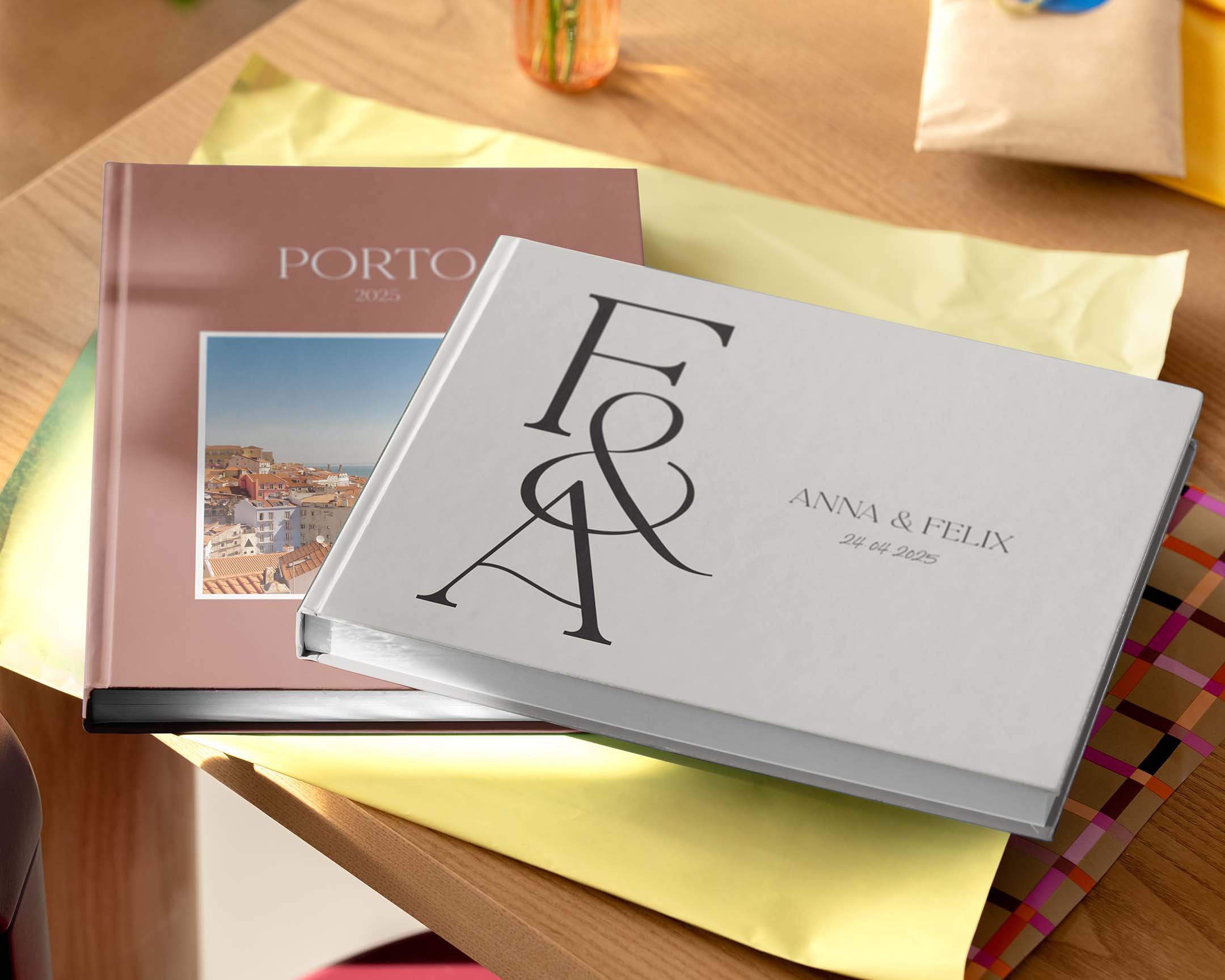 Due fotolibri personalizzati di diverse dimensioni e design esposti su un tavolo.