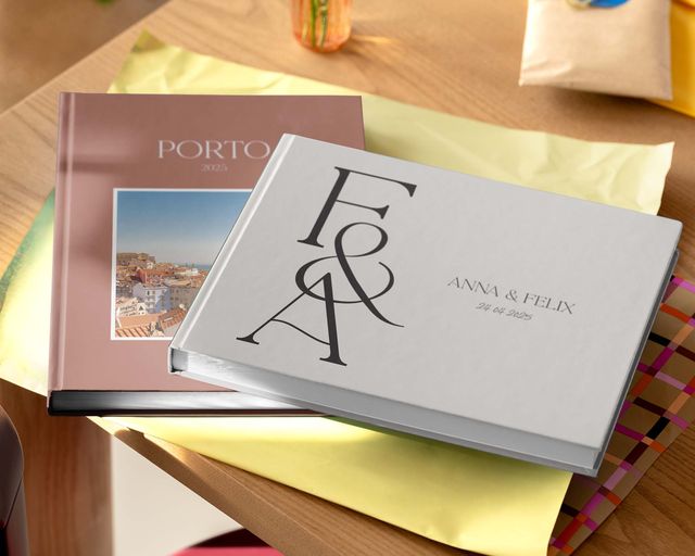 Due fotolibri personalizzati di diverse dimensioni e design esposti su un tavolo.