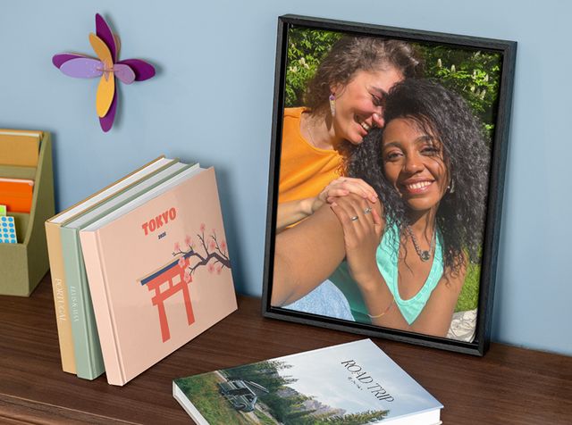 Una decorazione da parete personalizzata e diversi fotolibri personalizzati su uno scaffale