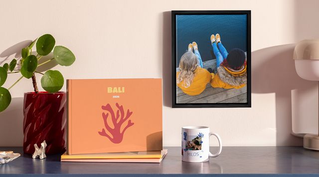 Foto prodotti personalizzati di Photobox tra cui un fotolibro, una decorazione da parete con cornice e una tazza.