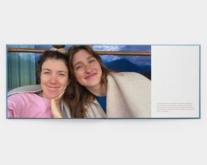 Un fotolibro orizzontale aperto con una foto di due donne che sorridono