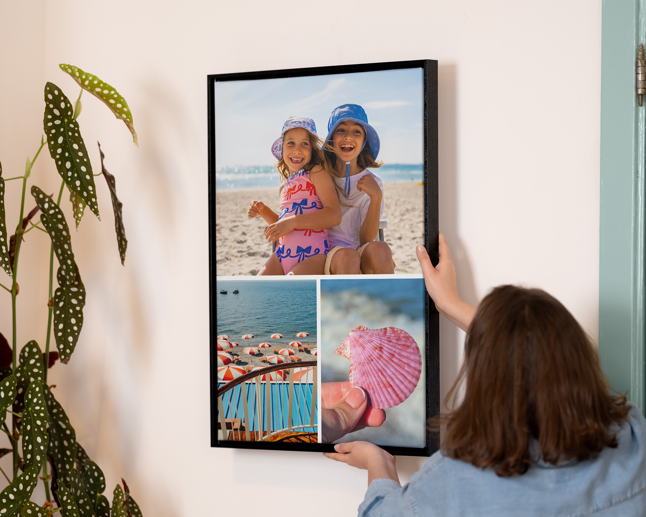 Persona che appende una stampa collage con cornice